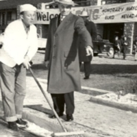 Honorary Mayor Bing Crosby sweeping Elko street supervised by Mayor Dave Dotta, 1948